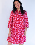 Model wearing red dress with pink flower print.