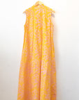 Display of yellow sleeveless dress with abstract pink print.