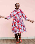 Model wearing a red, grey and maroon geometric shirt dress