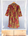 Display of brown dress with red snap pea print.