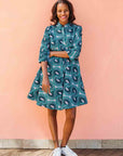 Model wearing dress with teal shaded loop print.