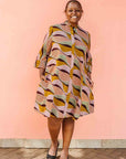 Model wearing neutral color geometric print dress.
