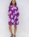 Woman wearing a purple floral dress against a white background