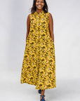 Model wearing yellow dress with black and white paisley print.