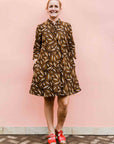 model wearing a brown, black and white seed design dress