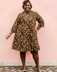model wearing a brown, black and white seed design dress