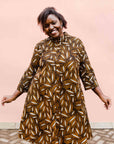 model wearing a brown, black and white seed design dress