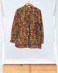 Display of mustard long sleeve blouse with red floral print.