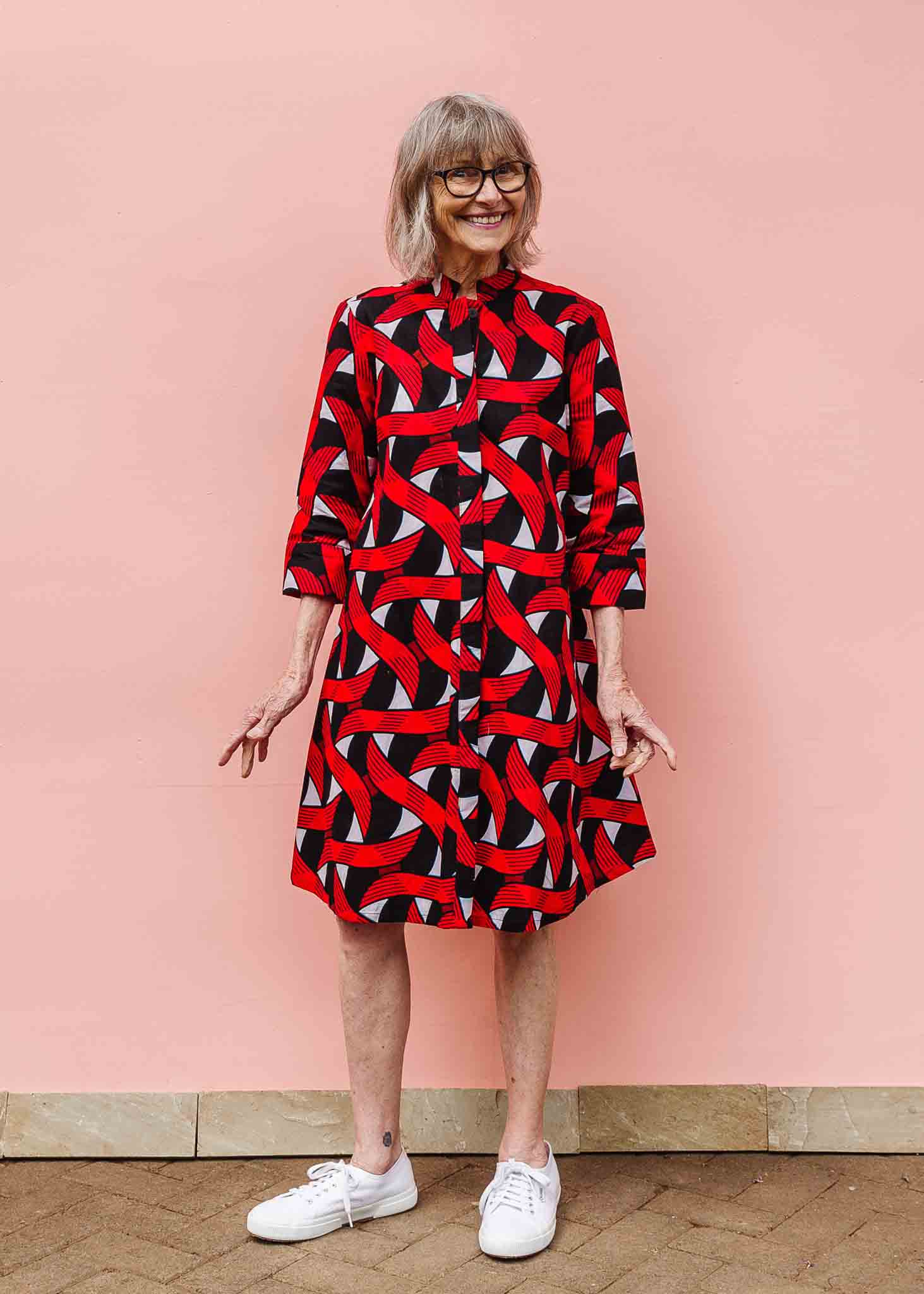 Model wearing red, black and white ribbon print dress.
