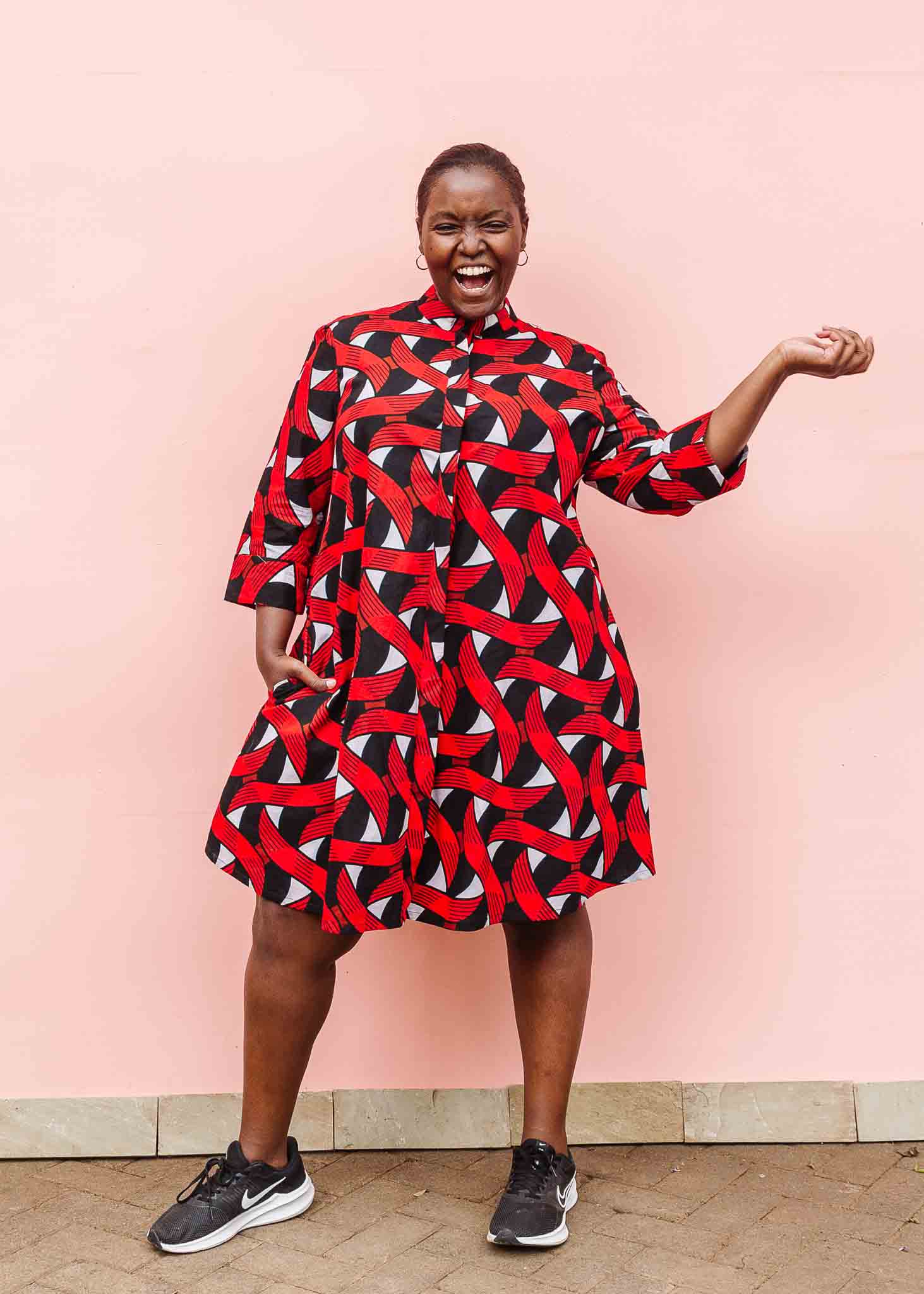 Model wearing red, black and white ribbon print dress.