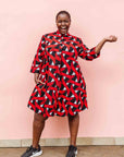 Model wearing red, black and white ribbon print dress.