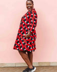 Model wearing red, black and white ribbon print dress.