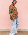 Model wearing mustard long sleeve blouse with red floral print.