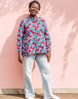 Model wearing pink, red, blue and black tube print long sleeve blouse.
