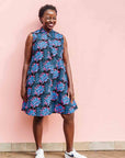 Model wearing black sleeveless dress with blue and pink poppy print.