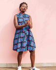 Model wearing black sleeveless dress with blue and pink poppy print.