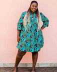 model wearing a green, red and yellow vegetable design dress