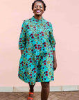 model wearing a green, red and yellow vegetable design dress