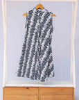 Display of white sleeveless dress with black and white zigzag print.