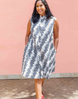 Model wearing white sleevless dress with black and white zigzag print.