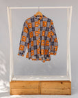 Display of orange, navy and white geometric print shirt.