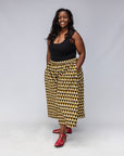 Model wearing black top with black and beige culotte.