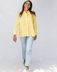 Model wearing yellow long sleeve shirt with white leaf print.