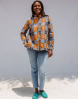 Model wearing orange, navy and white geometric print shirt.