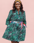 The model is wearing black, green and white geometric print dress