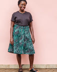 The model is wearing black, green and white geometric print dress