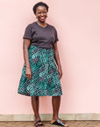 The model is wearing black, green and white geometric print dress