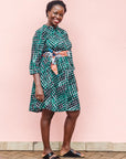 The model is wearing black, green and white geometric print dress
