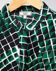 Display of black, green and white geometric print dress
