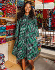 The model is wearing black, green and white geometric print dress