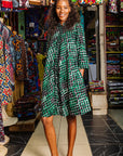 The model is wearing black, green and white geometric print dress