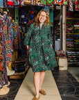 The model is wearing black, green and white geometric print dress