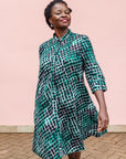 The model is wearing black, green and white geometric print dress