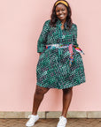The model is wearing black, green and white geometric print dress