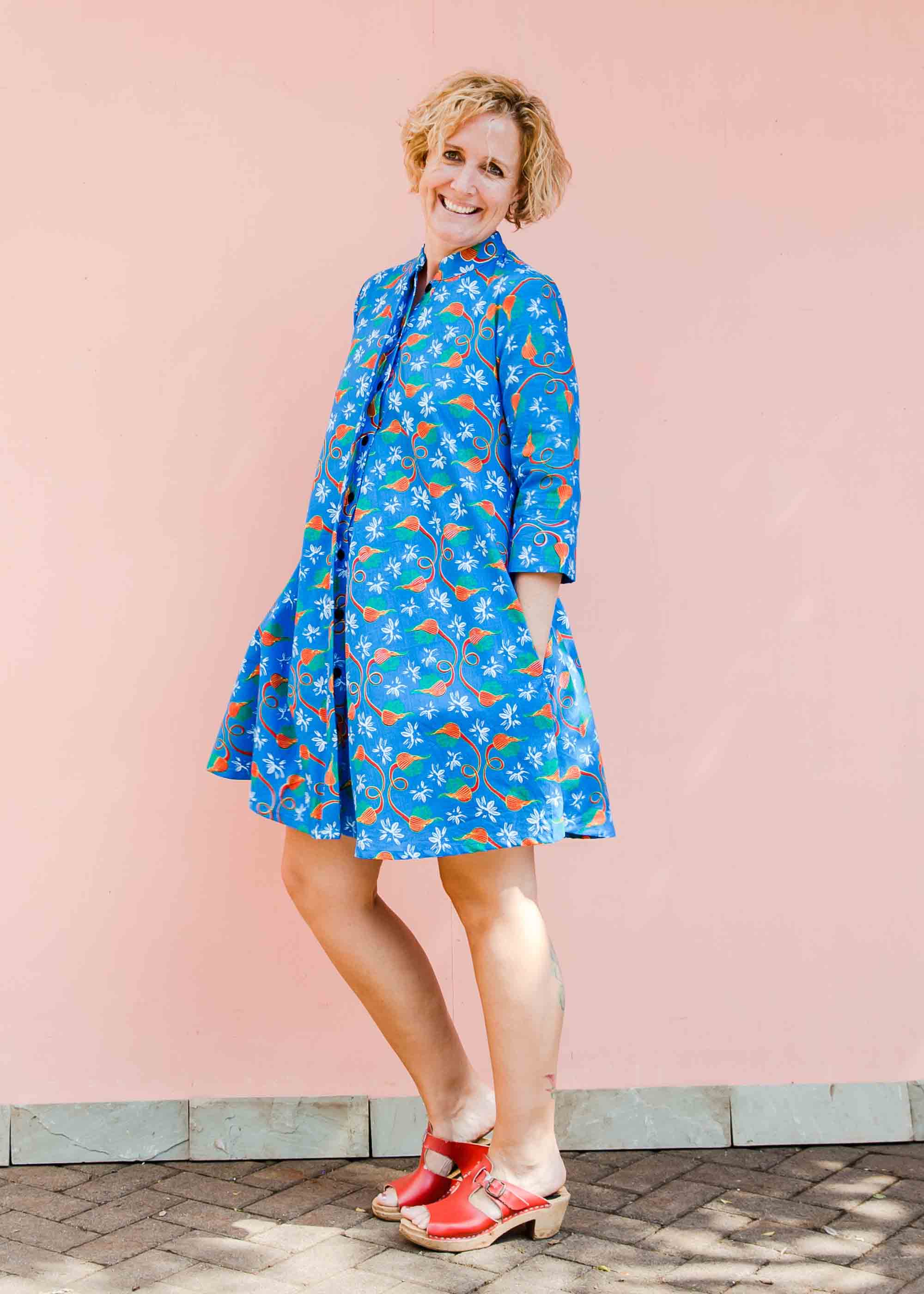 model wearing a blue, red and white flower pod design shirt dress