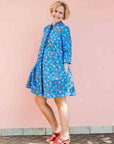model wearing a blue, red and white flower pod design shirt dress