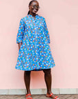 model wearing a blue, red and white flower pod design shirt dress
