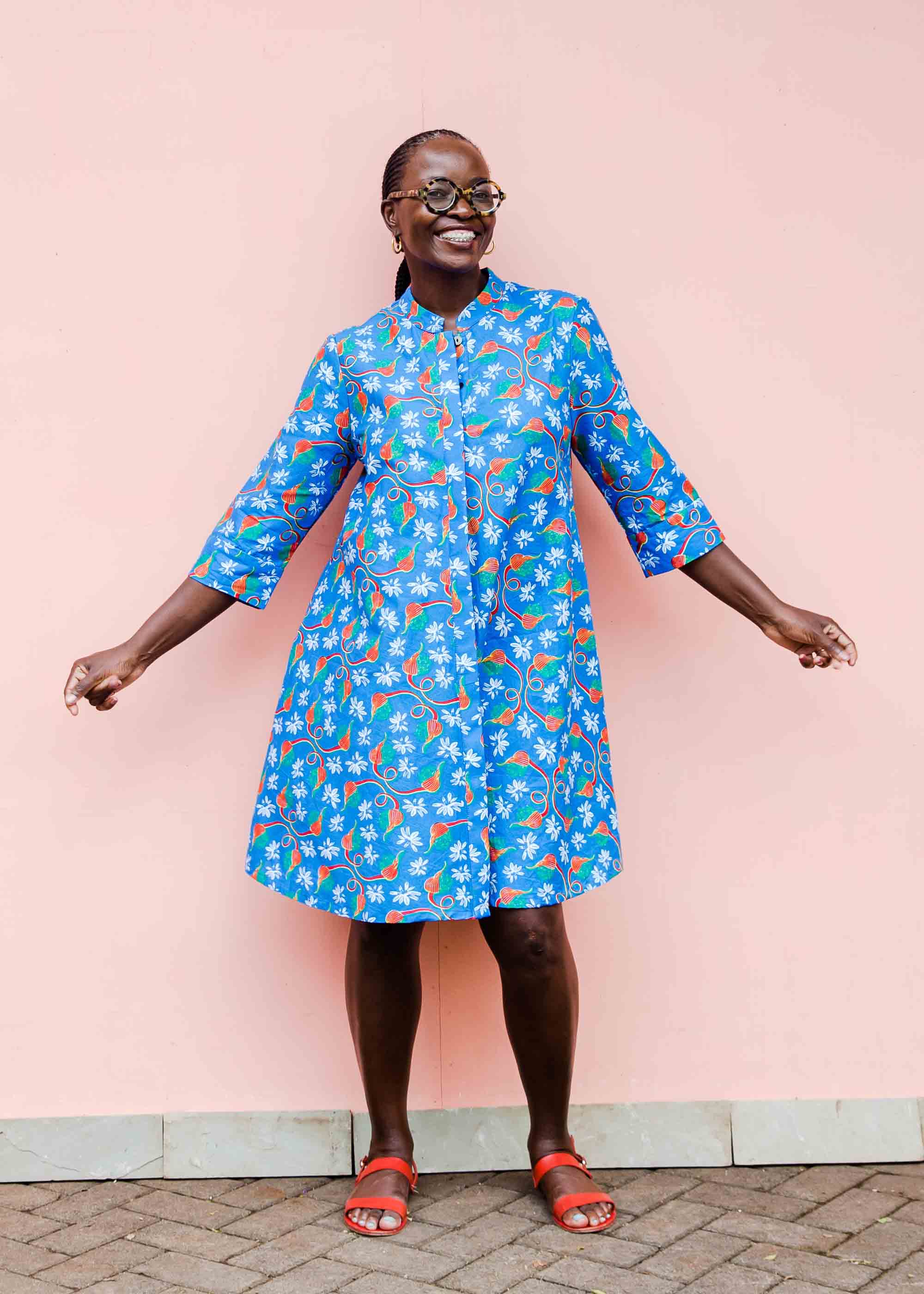 model wearing a blue, red and white flower pod design shirt dress