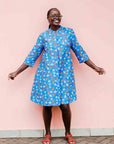 model wearing a blue, red and white flower pod design shirt dress