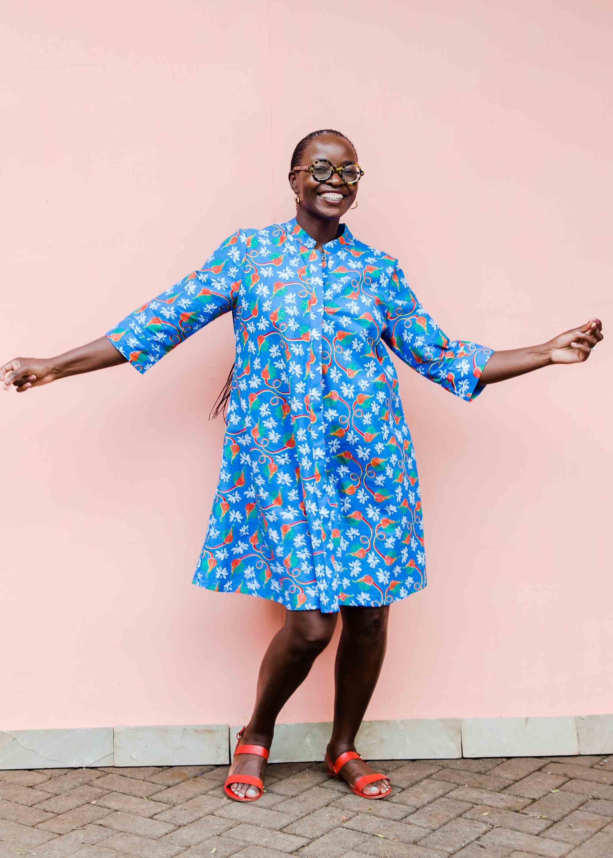 model wearing a blue, red and white flower pod design shirt dress