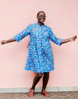 model wearing a blue, red and white flower pod design shirt dress