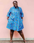 model wearing a blue, red and white flower pod design shirt dress