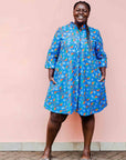model wearing a blue, red and white flower pod design shirt dress