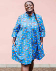 model wearing a blue, red and white flower pod design shirt dress