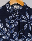 Display of navy dress with white floral print.