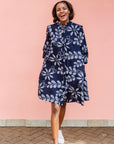 Model wearing navy dress with white floral print.